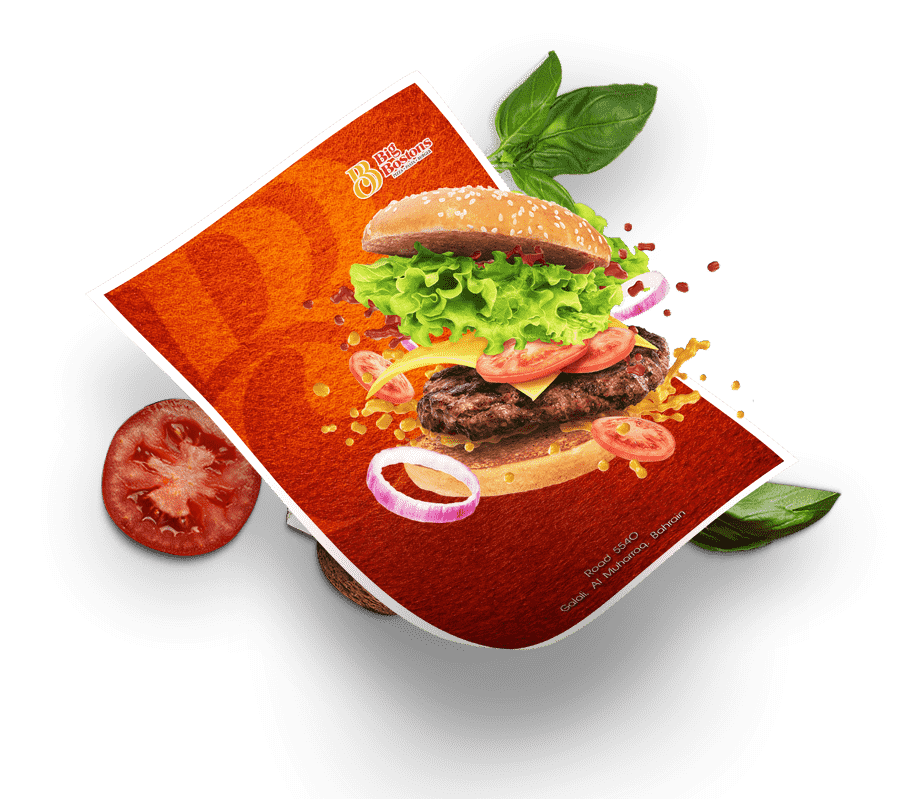 A hamburger and a fresh tomato placed on a white paper against a vibrant red background.